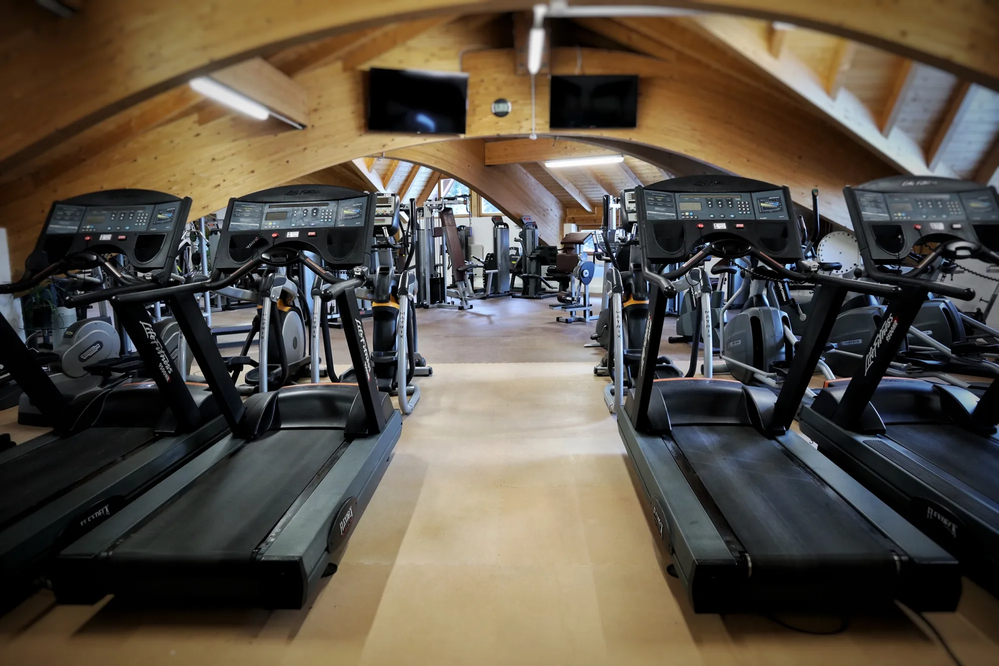 Cardio area with Life Fitness treadmills and cross trainers under the curved timber beams